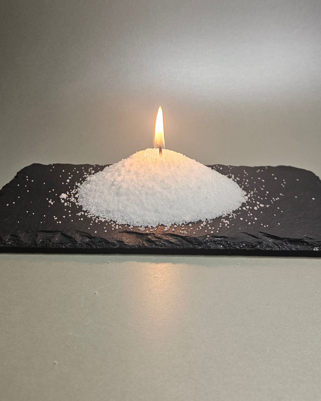 Brennende Kerze aus Sandwachs (Stearinsäure) mit kristalliner Oberfläche und sauberem Abbrand.