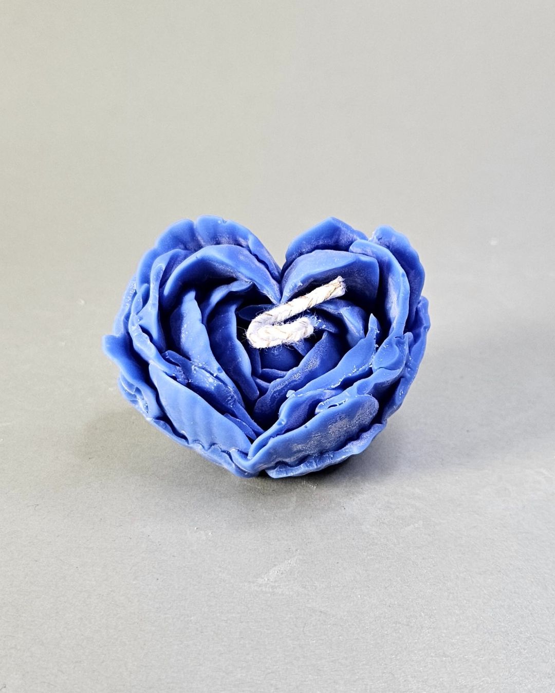 Handgefertigte Herzform-Blumenkerze aus Rapswachs in Blau, Nahaufnahme.