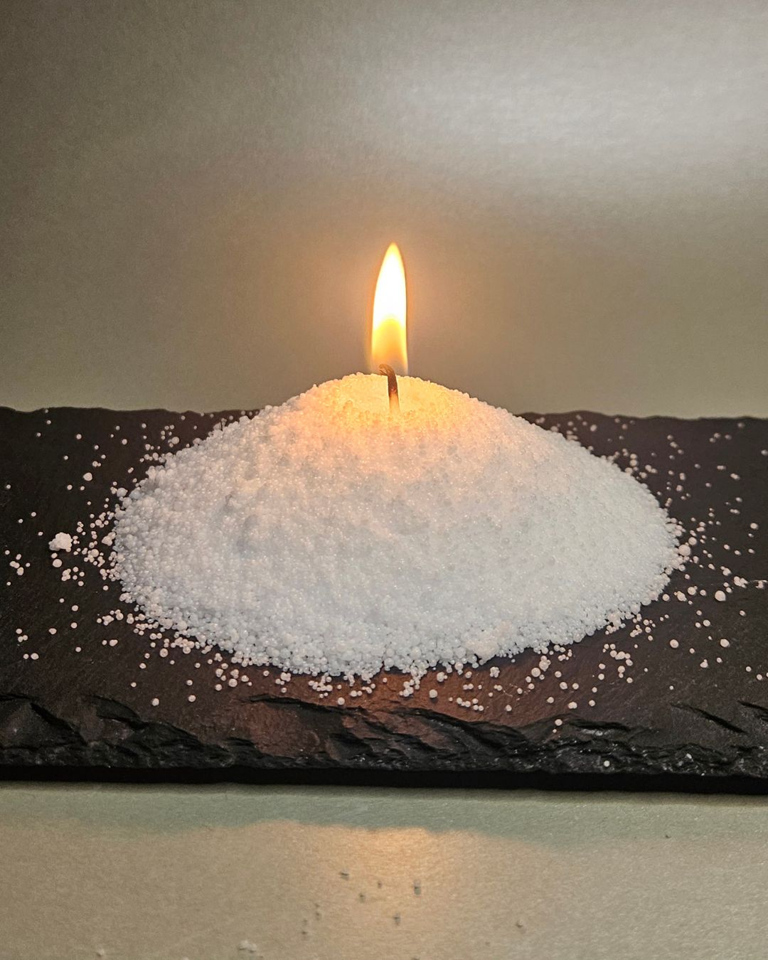 Flackernde Flamme einer mit Sandwachs (Stearinsäure) hergestellten Kerze, die gleichmäßig und rußfrei abbrennt.