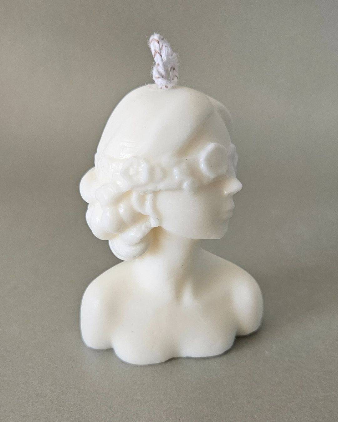 Seitliche Ansicht der detailreichen Skulpturenkerze „Frau mit verbundenen Augen“ aus Rapswachs – edle Handarbeit aus der Schweiz.